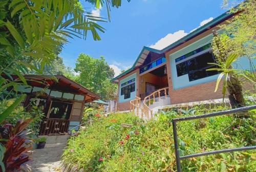 a house with a staircase leading up to it at Bonjorge Siquijor Hostel- Bagsa Branch in Larena