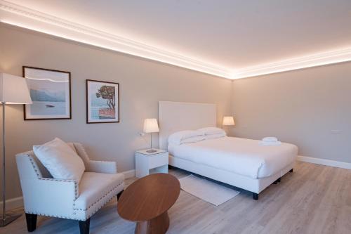 a bedroom with a bed and a chair and a table at Borgo Le Terrazze in Bellagio