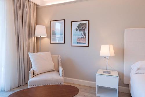 a room with a chair and a bed and a table at Borgo Le Terrazze in Bellagio
