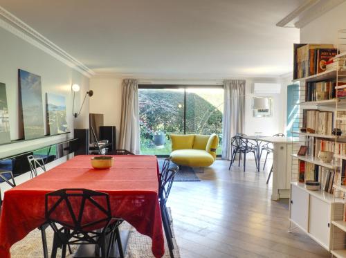 a living room with a red table and chairs at Beau 4 pièces avec grand jardin et tennis proche HEC et INRAE in Jouy-en-Josas