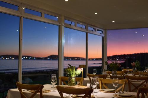 a dining room with a view of the water at Blue Bay Lodge in Saldanha