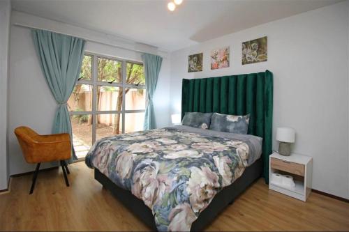 a bedroom with a bed with a green headboard and a window at The Great Escape in North Riding in Four Ways