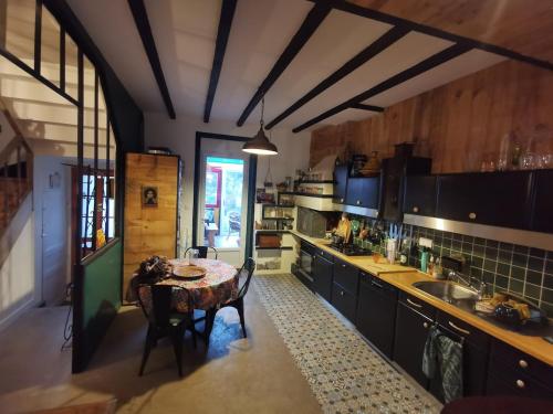 une cuisine avec une table au milieu dans l'établissement Ti ar veajerien, à Locmiquélic