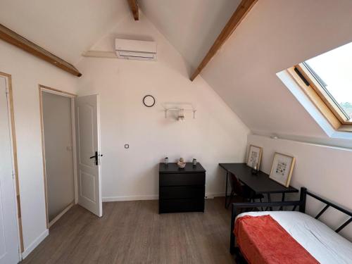 une chambre avec un lit, un bureau et une fenêtre dans l'établissement Charmante studette chez l'habitant, à Poissy