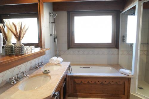 a bathroom with two sinks and a bath tub at Au Vieux Moulin in Megève