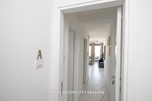 a hallway with white walls and white tile floors at Lazuli Seaview Apartments 2Bdr in Larnaka