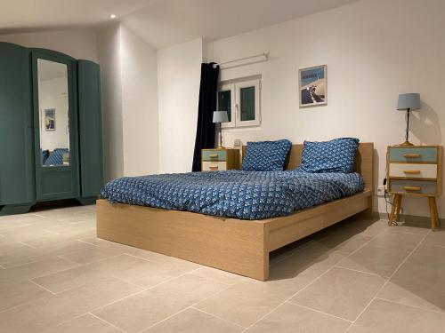 une chambre avec un lit avec des oreillers bleus dessus dans l'établissement Villa avec Piscine et terrain de pétanque proche Avignon, à Rognonas