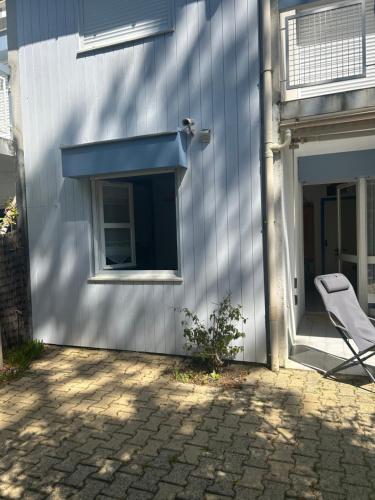 une chaise à côté d'un bâtiment avec fenêtre dans l'établissement appartement T3 très fonctionnel et central au Cap Ferret, à Cap-Ferret