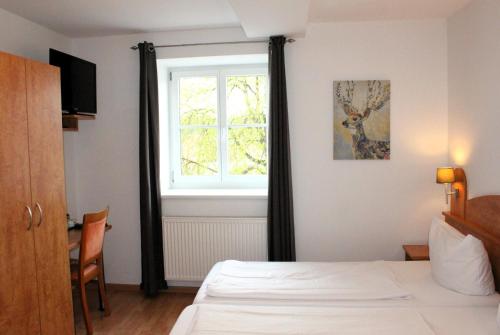 a bedroom with a bed and a window at Hotel Waitzingers in Landsberg am Lech