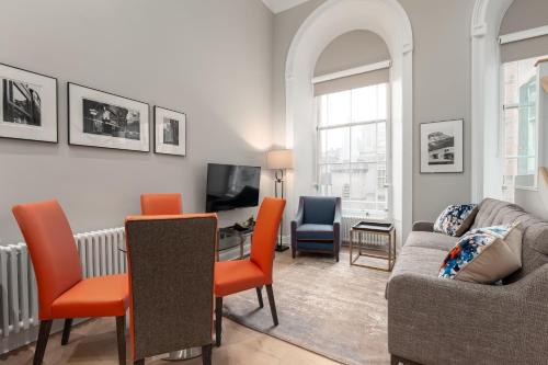 a living room with a couch and a table at Destiny Scotland George IV Apartments in Edinburgh