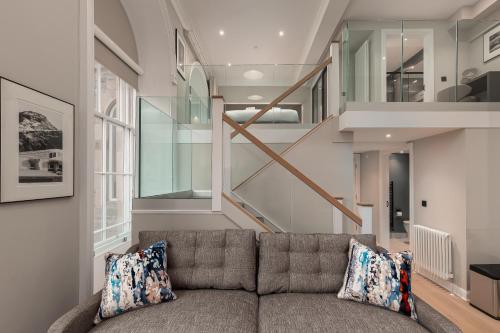 a living room with a couch and a staircase at Destiny Scotland George IV Apartments in Edinburgh