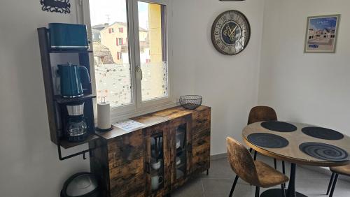 ein Esszimmer mit einem Tisch und einem Fenster in der Unterkunft Le "Chic en Ville" Centre historique, climatisé, wifi, Parking sous-sol inclus in Bergerac