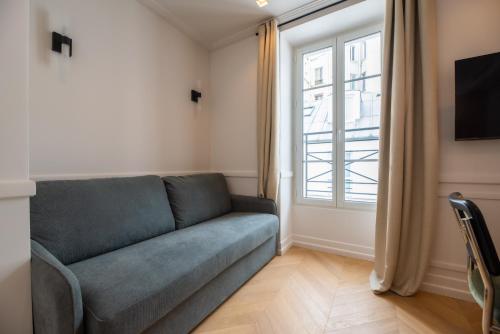 un salon avec un canapé et une fenêtre dans l'établissement Cute one bedroom Flat near Bastille, à Paris