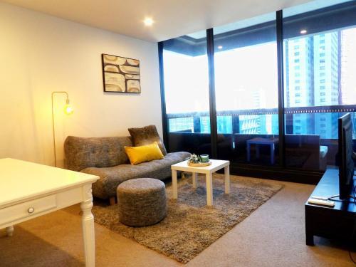 a living room with a couch and a table at ES2410-2Bed 2Bath Vision Apt with Balcony, Pool & Gym in Melbourne
