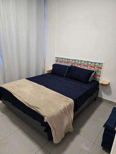 a bedroom with a large bed with a blue comforter at 100m da praia de Copacabana in Rio de Janeiro