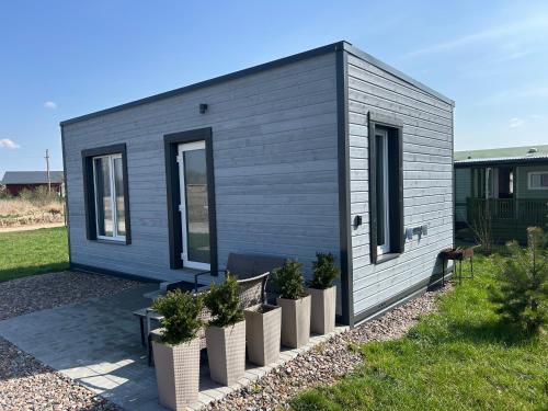 una piccola casa con piante in vaso in un cortile di Jaukus Namelis Šventojoje a Palanga