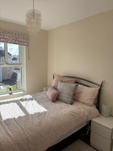 - une chambre avec un lit, un lustre et une fenêtre dans l'établissement Portrush West Strand, Seaviews, 2 balconies sleeps 6, à Portrush