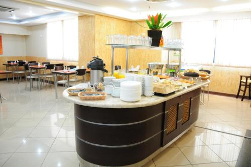a breakfast buffet in a restaurant with tables and chairs at Brasília Santana Gold Flat in Sao Paulo