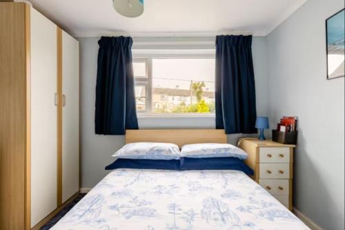 a bedroom with a bed with blue curtains and a window at Bed & Breakfast Only - not 24 hour lodging - Truro, Cornwall - free parking in Truro
