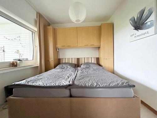 a bed in a small room with a large window at Ferienwohnung Körbecke am Möhnesee in Möhnesee