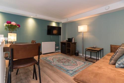 a living room with a couch and a table with a desk at 1001 Nights Boutique Lofts in Haarlem