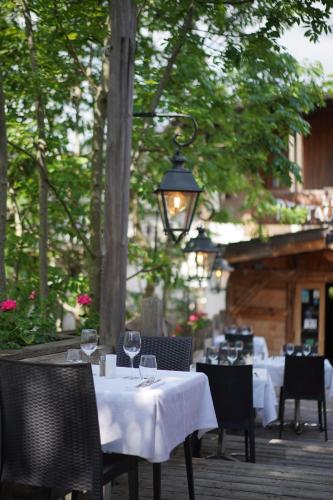a restaurant with tables and chairs with wine glasses at Au Vieux Moulin in Megève