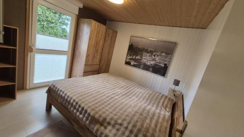 a bedroom with a bed and a large window at Ferienhaus 265 am Zeulenrodaer Meer in Zadelsdorf