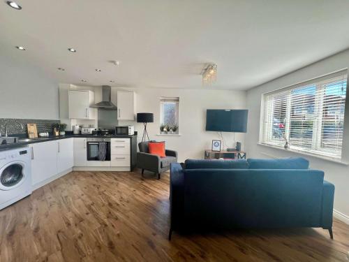 a living room with a blue couch and a kitchen at Swan House in Pallion