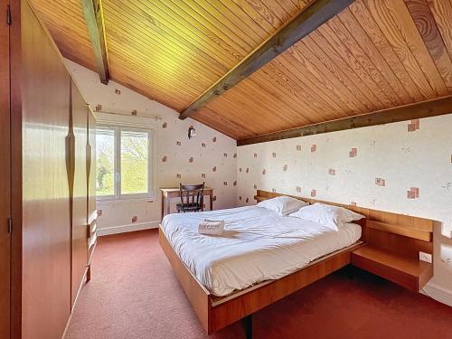 ein Schlafzimmer mit einem großen Bett und einer Holzdecke in der Unterkunft Chez Maurice Maison familiale & Campagne in Mazaye