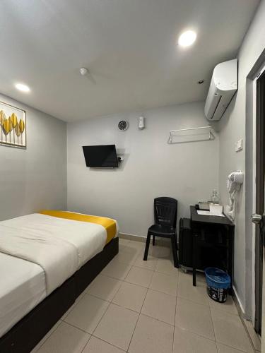 a hotel room with a bed and a desk and a chair at SS Grey Hotel 2 in Kuala Lumpur