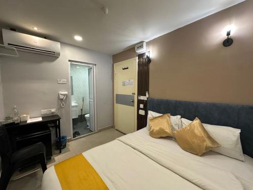 a bedroom with a bed with a desk and a sink at SS Grey Hotel 2 in Kuala Lumpur