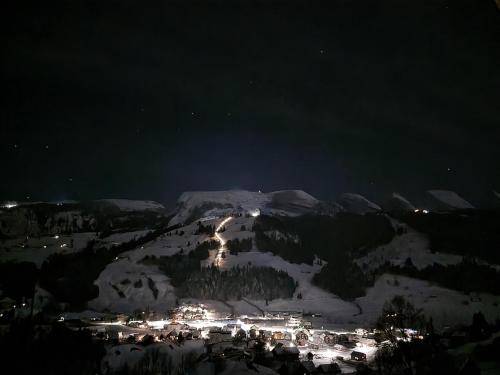 a snow covered mountain at night with a town at Ferienwohnung Toggilodge in Unterwasser