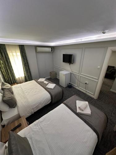 a hotel room with two beds and a television at Grand Heykel Hotel in Bursa