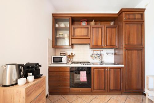 a kitchen with wooden cabinets and a stove top oven at L'angolo di Anna in Pieve di Soligo
