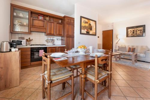 a kitchen and dining room with a wooden table and chairs at L'angolo di Anna in Pieve di Soligo