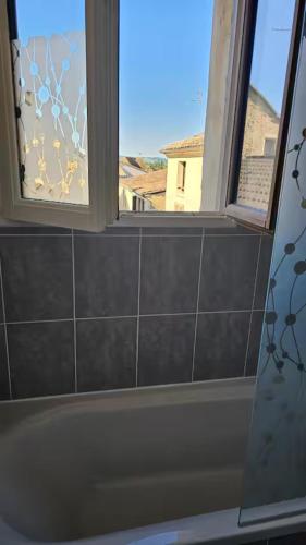 La salle de bains est pourvue de 2 fenêtres et d'une baignoire. dans l'établissement Le 