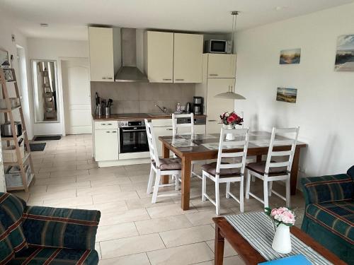 a kitchen and living room with a table and chairs at Ferienhaus in Hoben mit Grill und Terrasse in Zierow