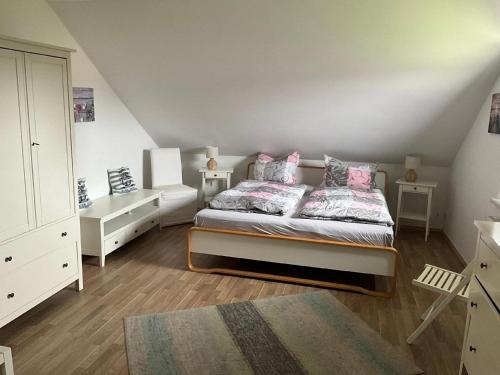 a bedroom with a bed with pink pillows and a dresser at Ferienhaus in Hoben mit Grill und Terrasse in Zierow