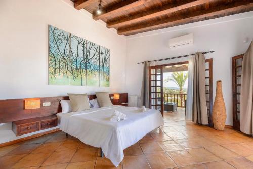 ein Schlafzimmer mit einem Bett und einem Gemälde an der Wand in der Unterkunft Can Blay in Santa Eulària des Riu