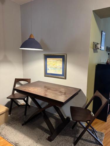 a dining room table with two chairs and a pendant light at OldTown Apartments Ferhadija in Sarajevo