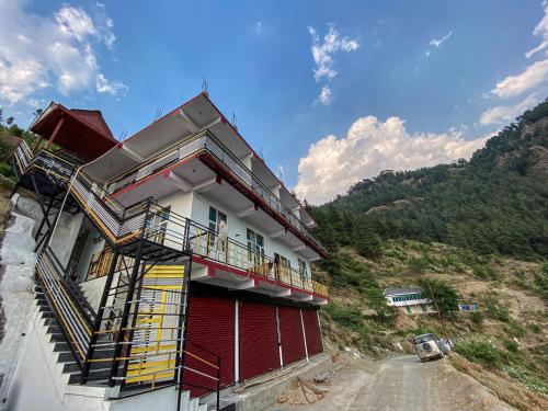 a red and white building on a dirt road at Scenic Village Stay near Kufri With Bonfire & Veg Meals-Alpine Crest Homestay Kufri in Theog