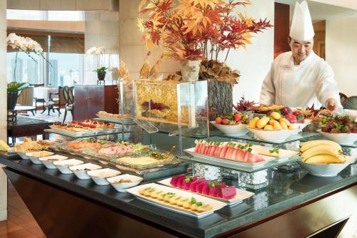 a chef standing in front of a buffet of food at Pudong Shangri-La Shanghai - With a sweeping view of the Pearl Tower and the historic Bund skyline in Shanghai