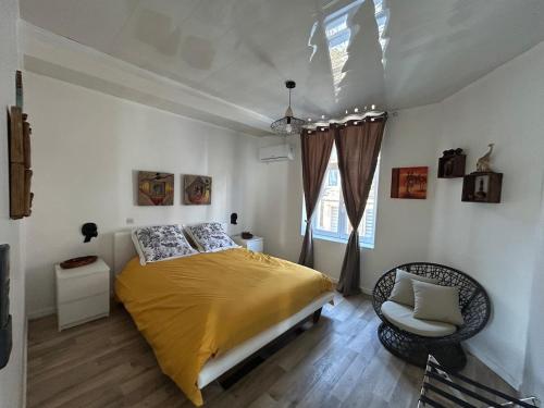 a bedroom with a bed and a chair and a window at Superbe appart rénové vue sur Meuse Miss Africa in Bogny Sur Meuse