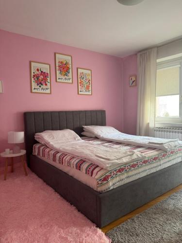 a bedroom with a bed with pink walls at OldTown Apartments Ferhadija in Sarajevo