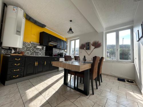 a kitchen with a wooden table and some chairs at Superbe appart rénové vue sur Meuse Miss Africa in Bogny Sur Meuse
