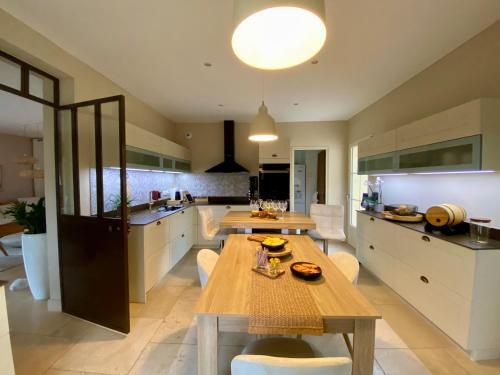 une grande cuisine avec une table et des chaises en bois dans l'établissement Villa CHARRE Mas Provençal avec piscine privée, à Ceyreste