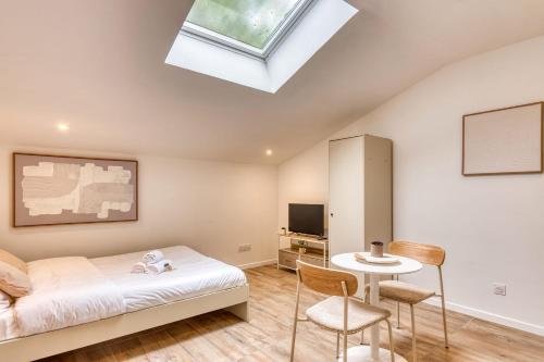 a bedroom with a bed and a skylight at La Suite Sable - Cosy studio - Proche Métro B in Oullins