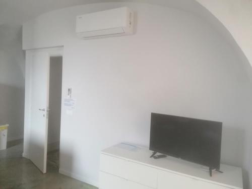 a flat screen tv sitting on a white wall at Allegra22 in Sale Marasino