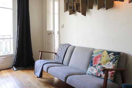 un salon avec un canapé et une fenêtre dans l'établissement Nice T2 - near Palais Garnier, à Paris