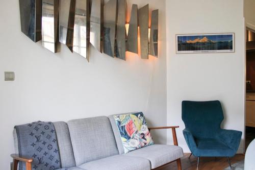 un salon avec un canapé et une chaise bleue dans l'établissement Nice T2 - near Palais Garnier, à Paris